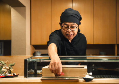 Sushi chef serving omakase across the counter at Sushi Shutatsu, a Tokyo sushi restaurant