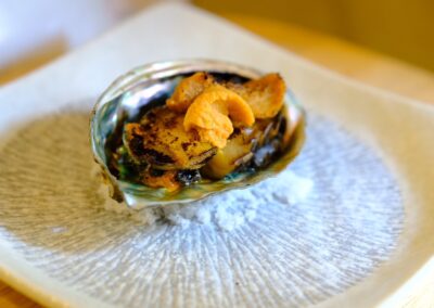 Grilled whole abalone topped with fresh sea urchin, served in its shell at Sushi Shutatsu in Ogikubo.