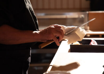 Sushi chef cleaning a Japanese knife during omakase preparation at Sushi Shutatsu in Ogikubo, Tokyo
