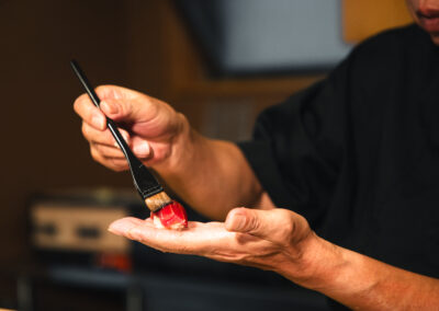 Chef brushing nikiri sauce onto a piece of tuna sushi at Sushi Shutatsu.